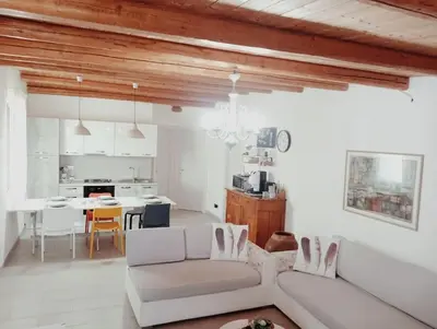 a living room with a white couch and a kitchen at Ciuri CiuriHome in Balestrate