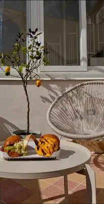 a plate with a sandwich and a tree on a table at La Maiolica 59 in Terrasini