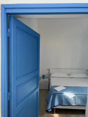 a blue door leading into a bedroom with a bed at La Maiolica 59 in Terrasini
