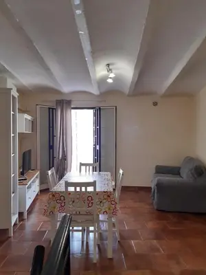 a living room with a table and a couch at La casa del cocchiere in Palermo
