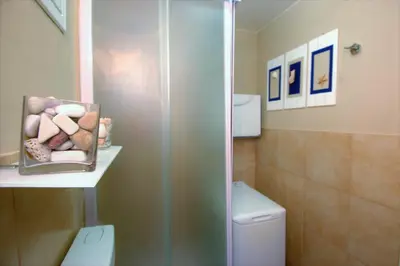 a bathroom with a shower and a toilet with rocks at Virna House a Castellammare del Golfo in Castellammare del Golfo