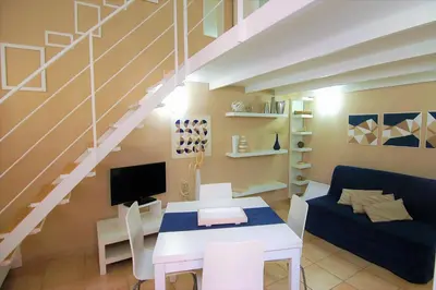 a living room with a white table and a staircase at Virna House a Castellammare del Golfo in Castellammare del Golfo