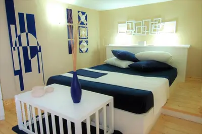 a bedroom with a bed with blue and white pillows at Virna House a Castellammare del Golfo in Castellammare del Golfo