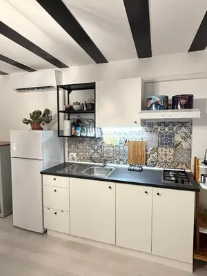 a kitchen with white cabinets and a black counter top at Casa Pipa in Palermo