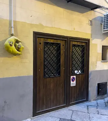 a building with a wooden door and a sign on it at Casa Pipa in Palermo
