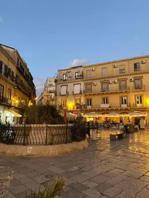 a group of buildings with tables and umbrellas at Casa Pipa in Palermo