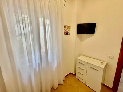 a kitchen with white cabinets and a counter top at Casa Meravigghia terrazzo ,giardino e Jacuzzi in Palermo