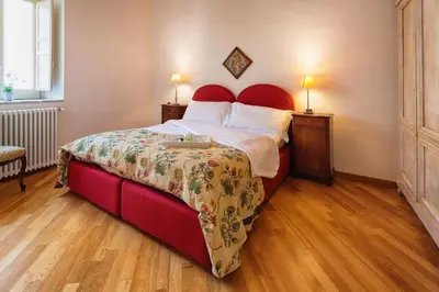 a bedroom with a large bed with a red headboard at Palazzo Mazzarino in Palermo