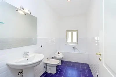 a white bathroom with a sink and a toilet at Palazzo Mazzarino in Palermo