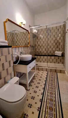 a bathroom with a toilet and a sink and a mirror at MaisonNouveau in Palermo