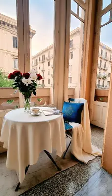 a table in a room with a vase of flowers at MaisonNouveau in Palermo