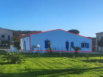 a large white building with a red stripe on it at Campofelice Holidays West Villa in Campofelice di Roccella