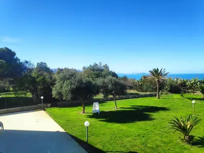 a park with a bench in the grass at Campofelice Holidays West Villa in Campofelice di Roccella