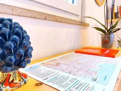 a table with a map and a vase with blue glasses at Stefy's Home #Cattedrale in Palermo