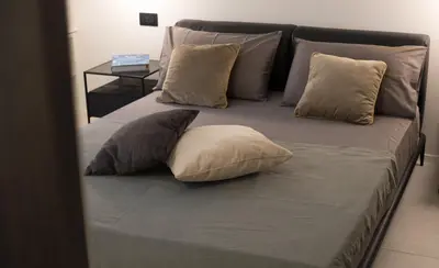 a bed with four pillows on it at G&M Place in Palermo
