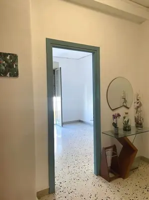a hallway with a doorway with a mirror and a table at Casa Visconti 170mq-centro storico in Palermo