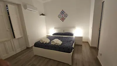 a bedroom with a bed with two towels on it at Dietro Ballarò - Guest House in Palermo