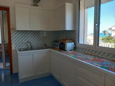 a kitchen with a counter with a sink and a window at Villa Aliotis in Alcamo Marina