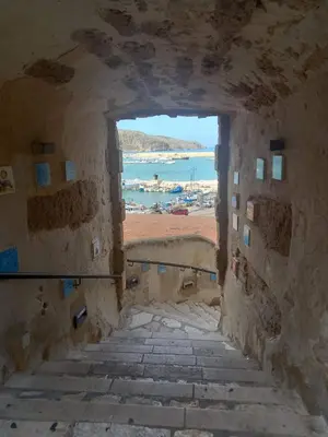 an archway in a stone wall with a view of the ocean at Casa Gerani in Castellammare del Golfo