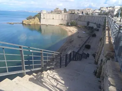a view of a beach next to a retaining wall at Casa Gerani in Castellammare del Golfo