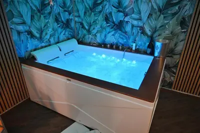 a bath tub in a room with a blue wall at Cala Sikula Suite &SPA in Palermo