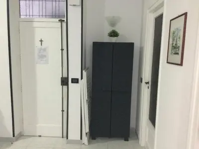 a black cabinet in a hallway next to a door at Elegante Appartamento Palermo in Palermo