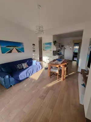 a living room with a blue couch and a table at Pietra Marina in Capaci
