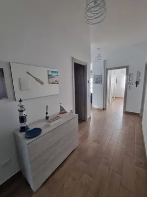 a large room with a wooden floor and white walls at Pietra Marina in Capaci