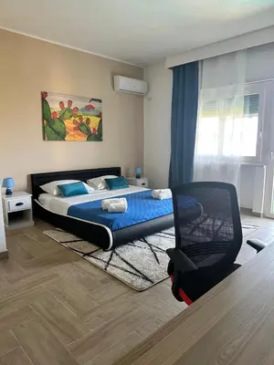 a bedroom with a bed and a chair in it at Addaura Luxury Apartment in Palermo