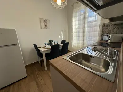 a kitchen with a sink and a table with chairs at Mortillaro 19 in Palermo