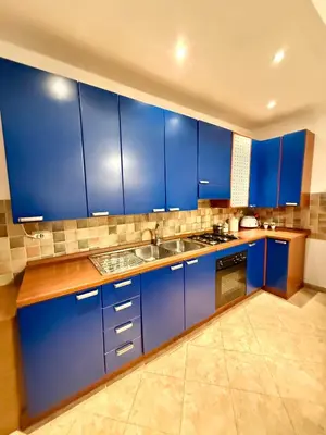 a blue kitchen with a sink and blue cabinets at Gigi's Apartment in Palermo