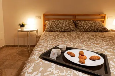 a tray of food on a bed with two cookies at Palermo Home Politeama in Palermo