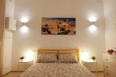 a bedroom with a bed and a painting on the wall at Palermo Home Politeama in Palermo