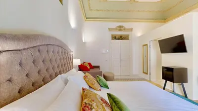 a bedroom with a bed and a flat screen tv at Palazzo Genuardi - charming rooms - in Palermo