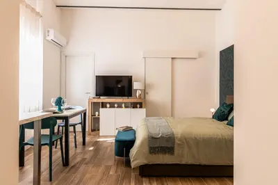 a bedroom with a bed and a desk and a table at Politeama Luxury Suite in Palermo