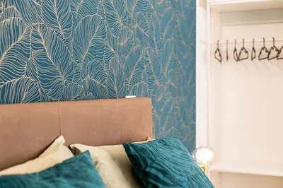 a living room with a couch and a blue and white wallpaper at Politeama Luxury Suite in Palermo