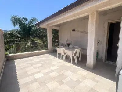 a patio with a table and chairs on a porch at Carini house in Carini