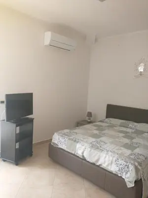a bedroom with a bed and a flat screen tv at Carini house in Carini