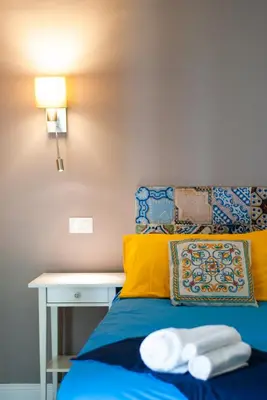 a bedroom with a blue bed and a desk at Palazzo Carella in Palermo