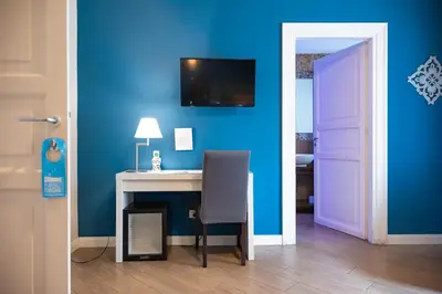 a room with a desk and a blue wall at Palazzo Carella in Palermo