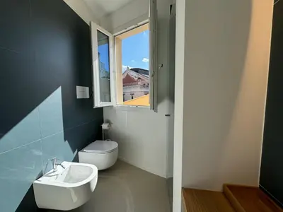 a bathroom with a toilet and a sink and a window at Politeama Libertà Home Sweet Home in Palermo