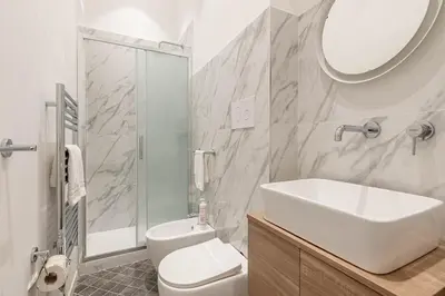 a bathroom with a sink and a toilet and a mirror at Turati Apartment al Politeama by Wonderful Italy in Palermo