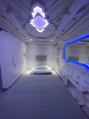 a small room with two beds and a light at Mermaid Space Capsule Hostel Palermo in Palermo