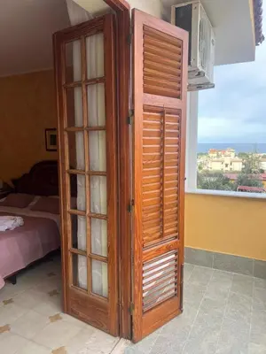 a wooden cabinet in a room with a window at Casa MaRo' in Capaci