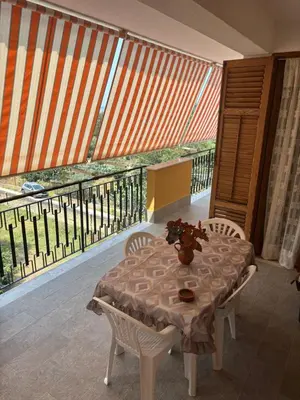 a table and chairs in a room with a balcony at Casa MaRo' in Capaci