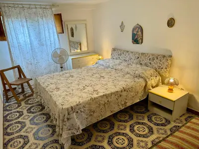 a bedroom with a bed and a table and a chair at Villa Mia in Carini
