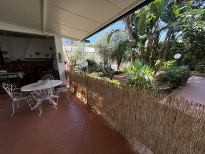a patio with a table and chairs and a fence at Villa Mia in Carini