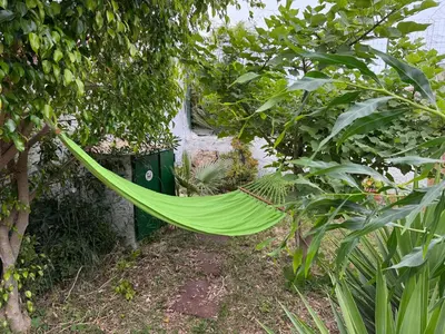 a green hammock hanging from a tree in a garden at Villa Mia in Carini