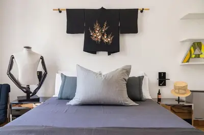a bedroom with a bed and a wall with clothes at Libertà Appartement in Palermo