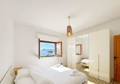 a white bedroom with a bed and a window at Solemar Sicilia - Ville Paradiso in Santa Flavia